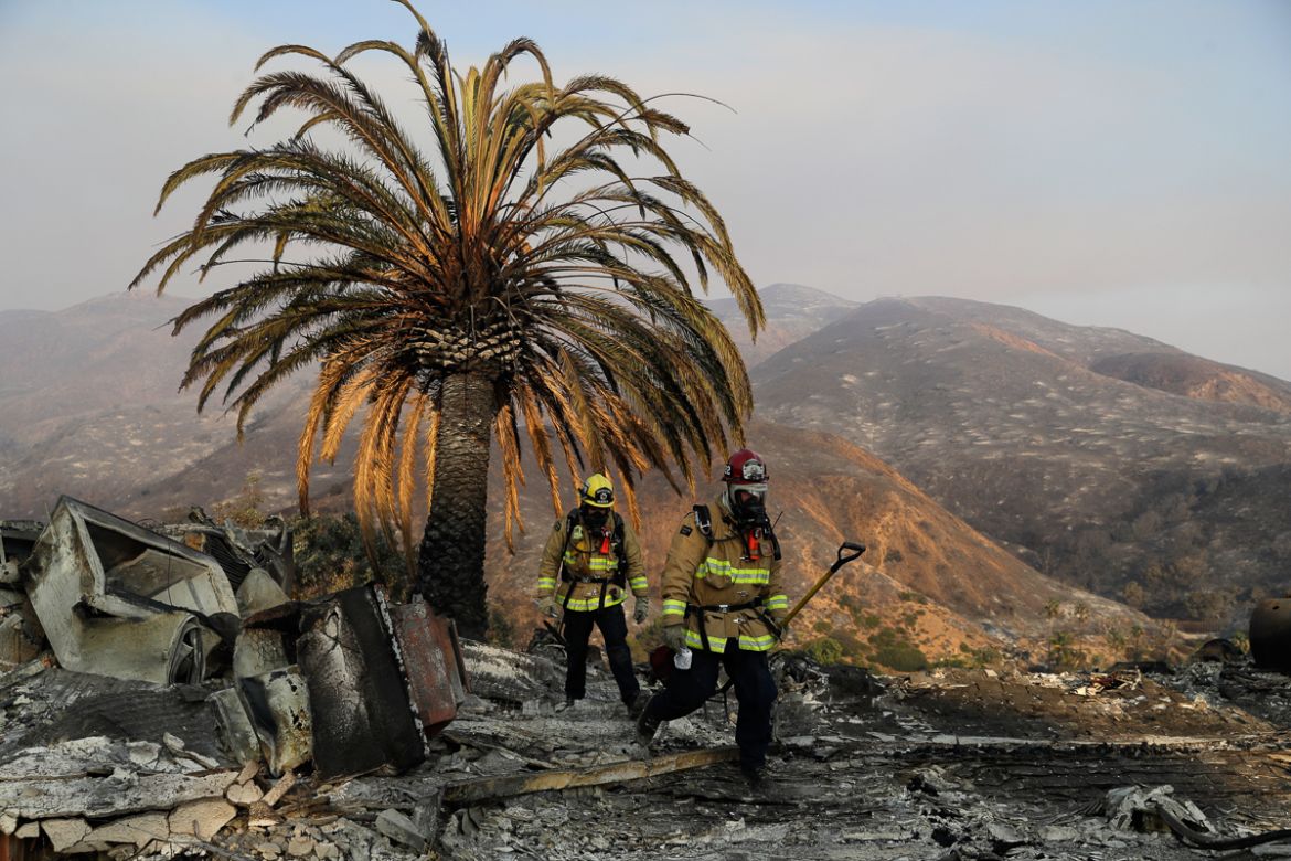 irefighters Jason Toole, right, and Brent McGill with the Santa Barbara Fire Dept. walk among the ashes of a wildfire-ravaged home after turning off an open gas line on the property Saturday, Nov. 10,