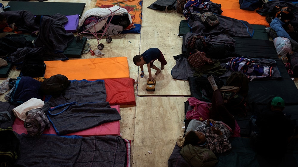 A four-year-old boy from Honduras plays with cars at a shelter in Tijuana, Mexico [Adrees Latif/Reuters] 