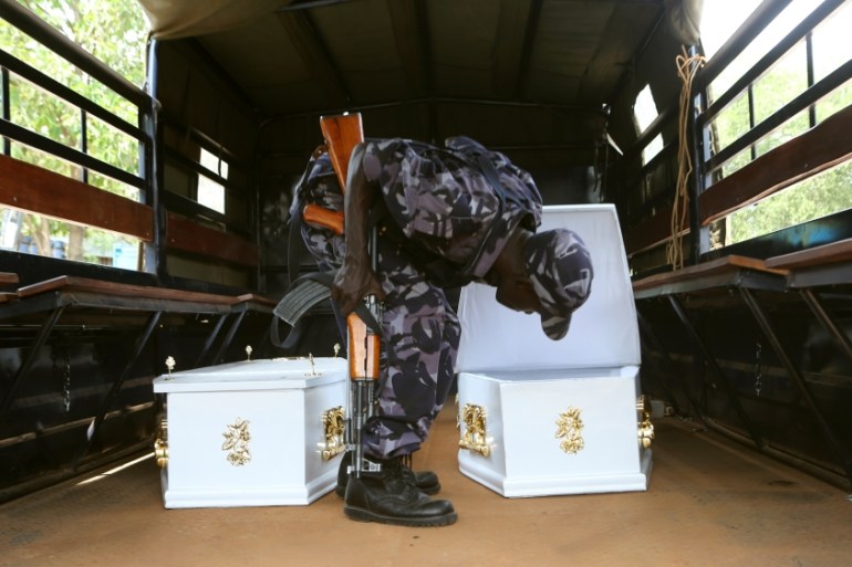A policeman opens a coffin''s lid before placing in his colleagues killed after Uganda security forces stormed the palace of Charles Wesley Mumbere, king of the Rwenzururu, in Kasese town