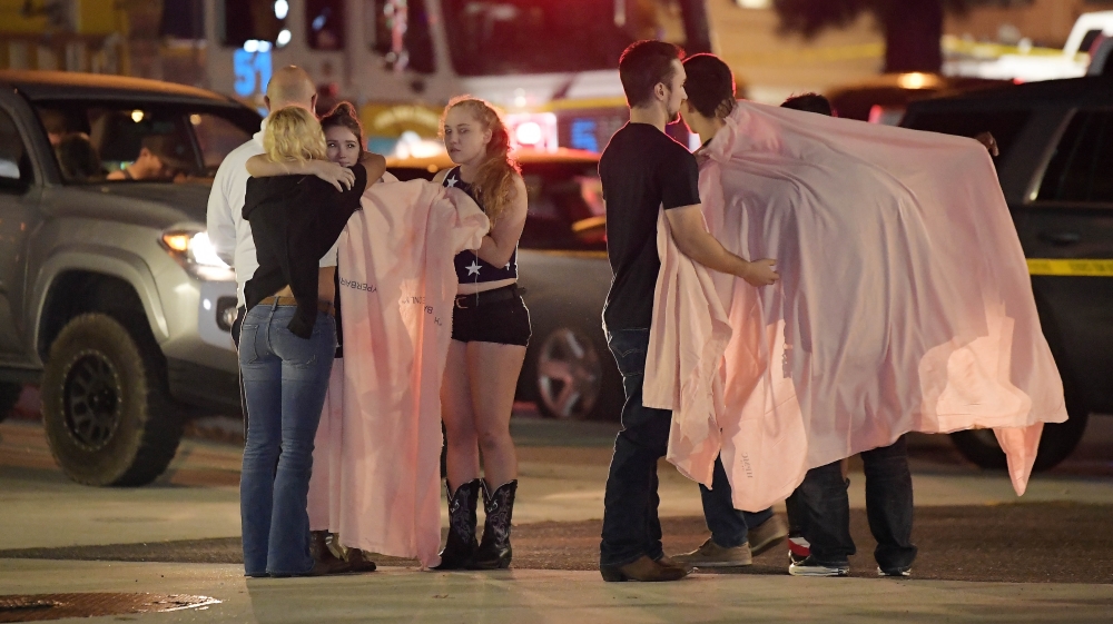 People comfort each other as they stand near the scene in Thousand Oaks, California [Mark J. Terrill/AP Photo]