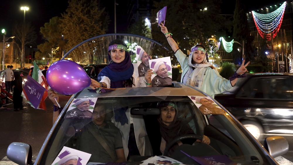 Supporters of Rouhani attend a street campaign ahead of his re-election in May 2017 [File: AP]