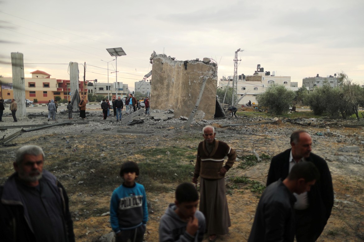 Palestinians gather around the remains of a building that was destroyed by an Israeli air strike, in Khan Younis in the southern Gaza Strip November 12, 2018. REUTERS/Suhaib Salem