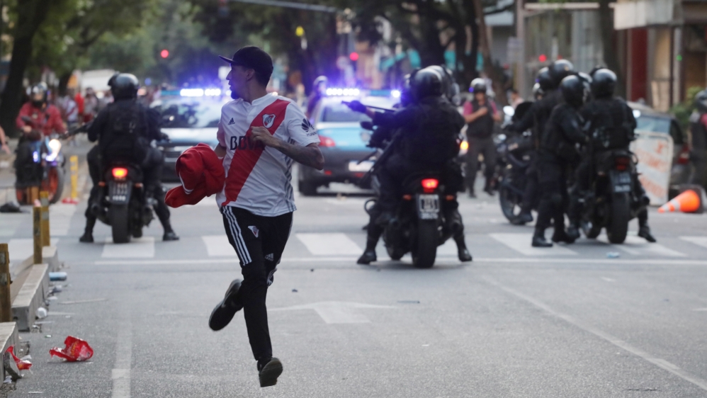 A fan of River Plate runs away after the match was postponed [Alberto Raggio/Reuters]