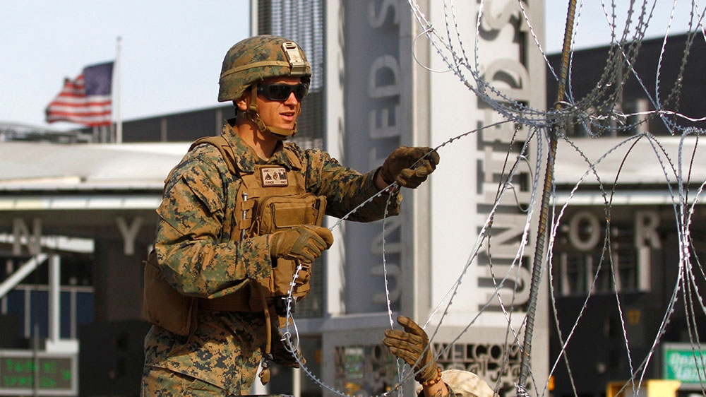 A US Marine sets up a barricade with concertina wire at the border between Mexico and the US [Jorge Duenes/Reuters] 