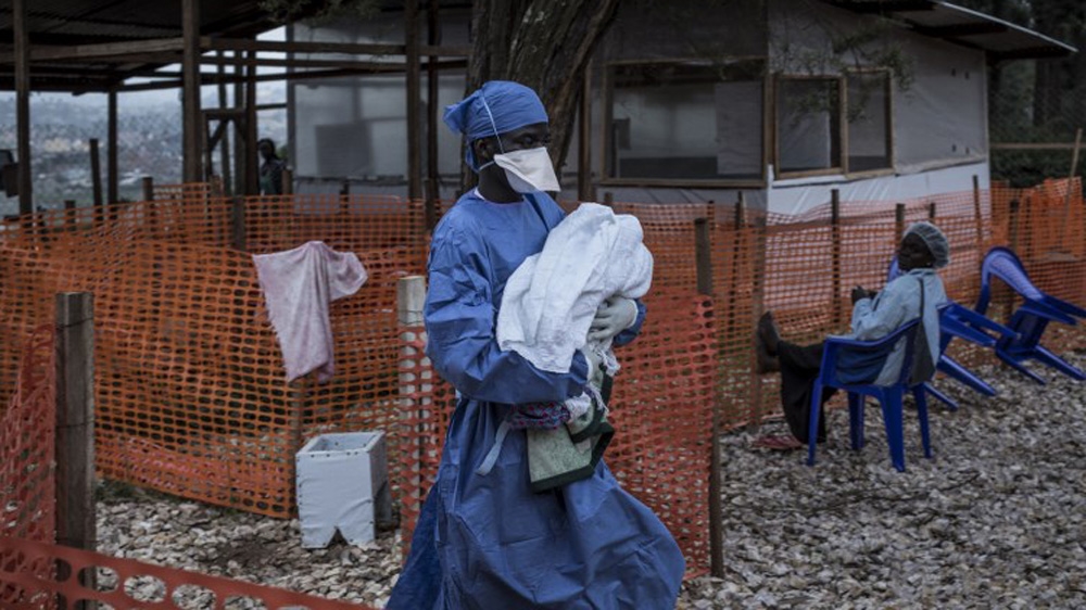 A health worker carries a four-day-old baby suspected of having Ebola, into a Doctors Without Borders-supported Ebola treatment centre in DRC [File: John Wessels/AFP]