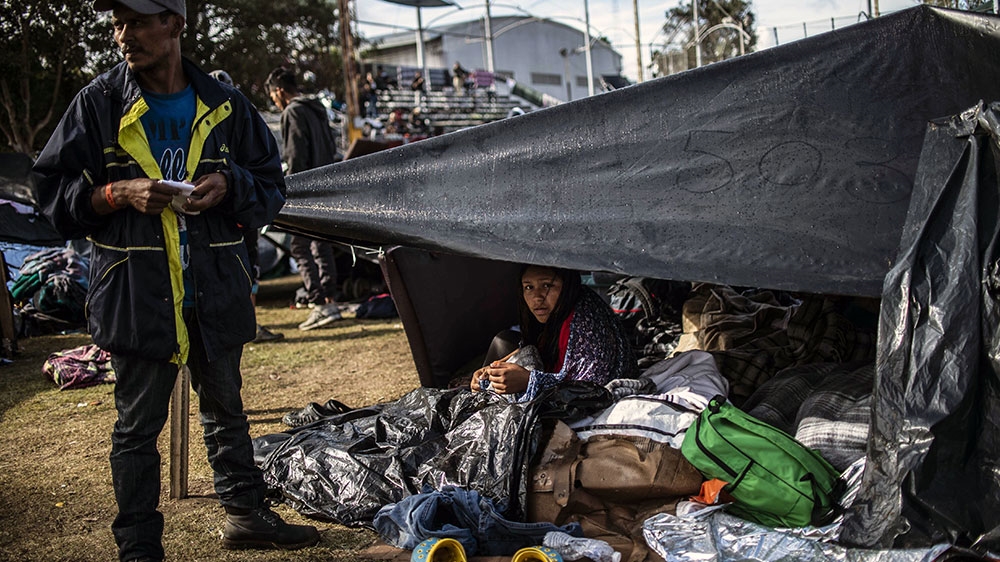 Central Americans remain at a shelter near the US-Mexico border fence in Tijuana [Pedro Pardo/AFP] 