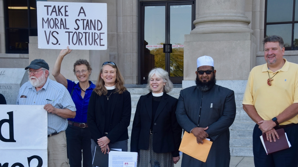 Christina Cowger (second from left in blue) and faith leaders in North Carolina protest torture [Al Jazeera]