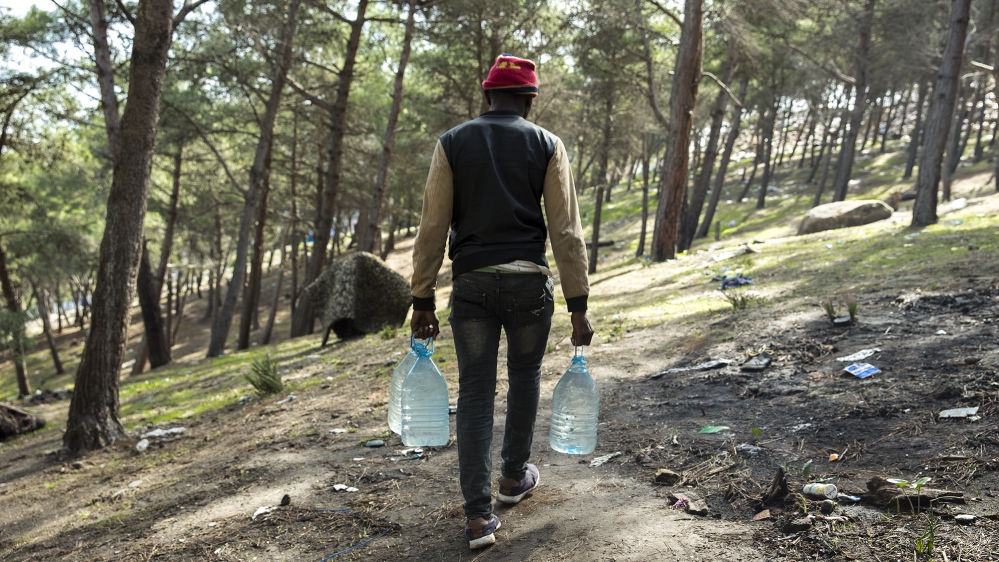 For drinking water, the migrants in Tangier forest head to a nearby source to fill their empty plastic bottles [Faras Ghani/Al Jazeera] 