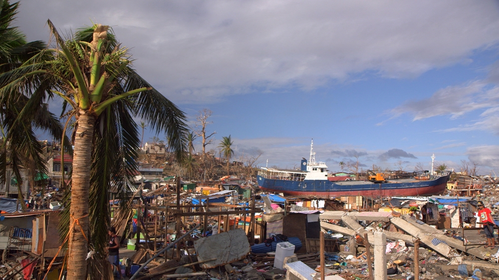 A cargo ship washed ashore by Typhoon Haiyan's waves sits among the debris in Tacloban, Philippines.  [Al Jazeera]
