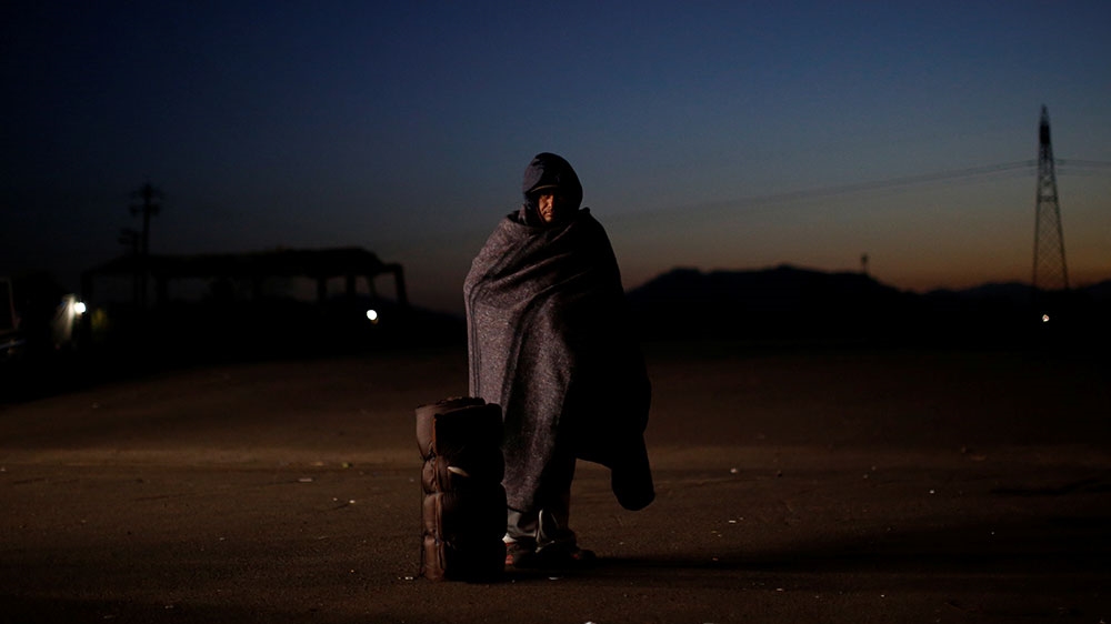 A migrant from Honduras, part of a caravan of thousands travelling from Central America to the US, prepares to get on a bus bound for Mexicali at a makeshift camp in Navojoa [Kim Kyung-Hoon/Reuters] 