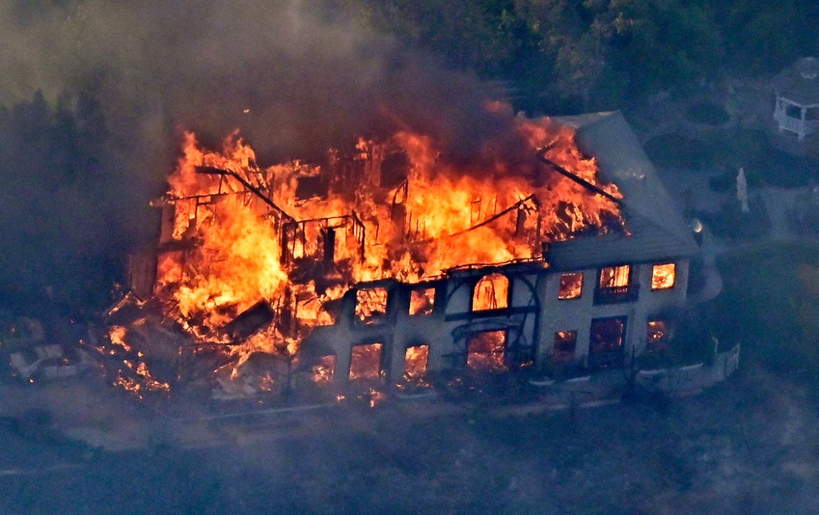 A home burns Friday, Nov. 9, 2018, as seen from a helicopter in the Calabasas section of Los Angeles. Flames driven by powerful winds torched dozens of hillside homes in Southern California, burning p