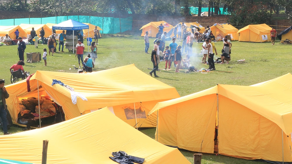 Cooking fires burn inside Bogota’s first tent camp for Venezuelan migrants, dubbed a humanitarian transit camp [Dylan Baddour/Al Jazeera]