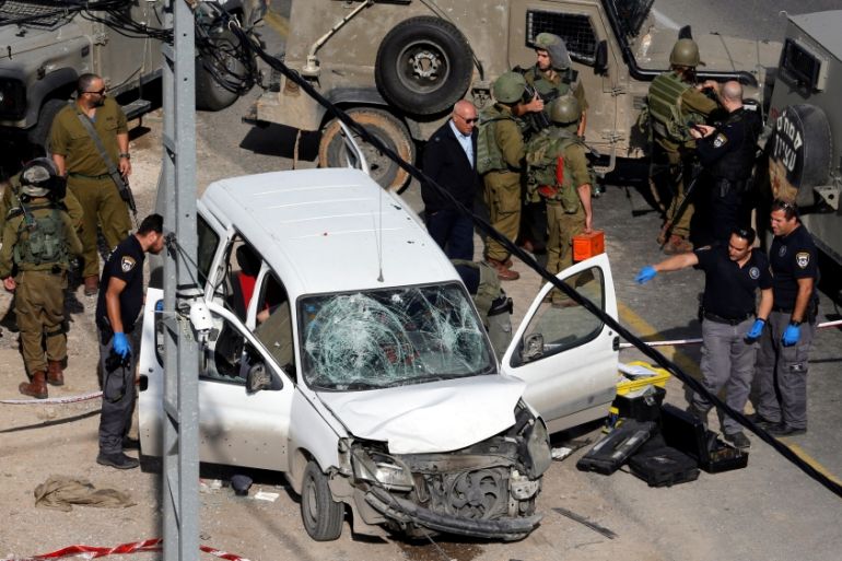 Israeli policemen inspect the scene of a car ramming attack near Hebron, in the occupied West Bank