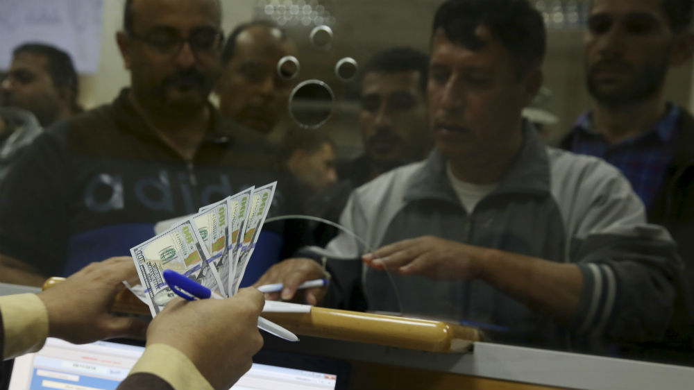 A Hamas government employee receives 60 percent of his long-overdue salary [Adel Hana/AP]