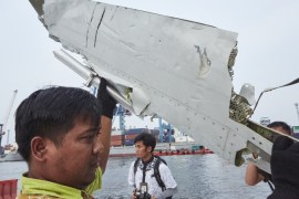 Man examines part of plane of Lion Air which crashed in 2018