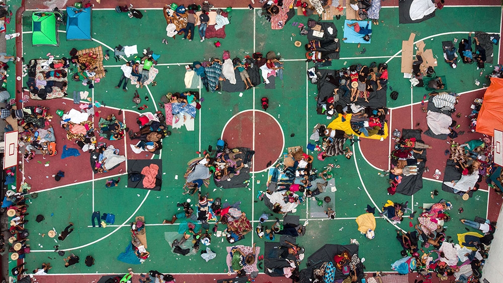 Aerial view of Honduran migrants heading in a caravan to the US, resting in a basketball pitch in San Pedro Tapanatepec, Oaxaca state, southern Mexico [Guillermo Arias/AFP] 