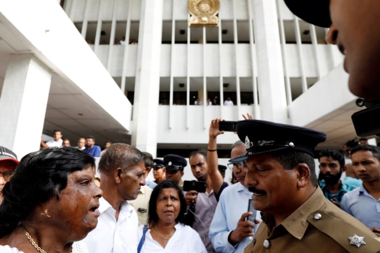 Sri Lanka''s police officer advises supporters of the deposed Prime Minister Ranil Wickremesinghe-led United National Party to leave the court premises in Colombo