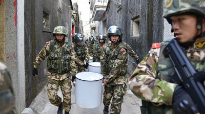 Paramilitary police carry seized crystal meth during a crackdown in southern China [Reuters]