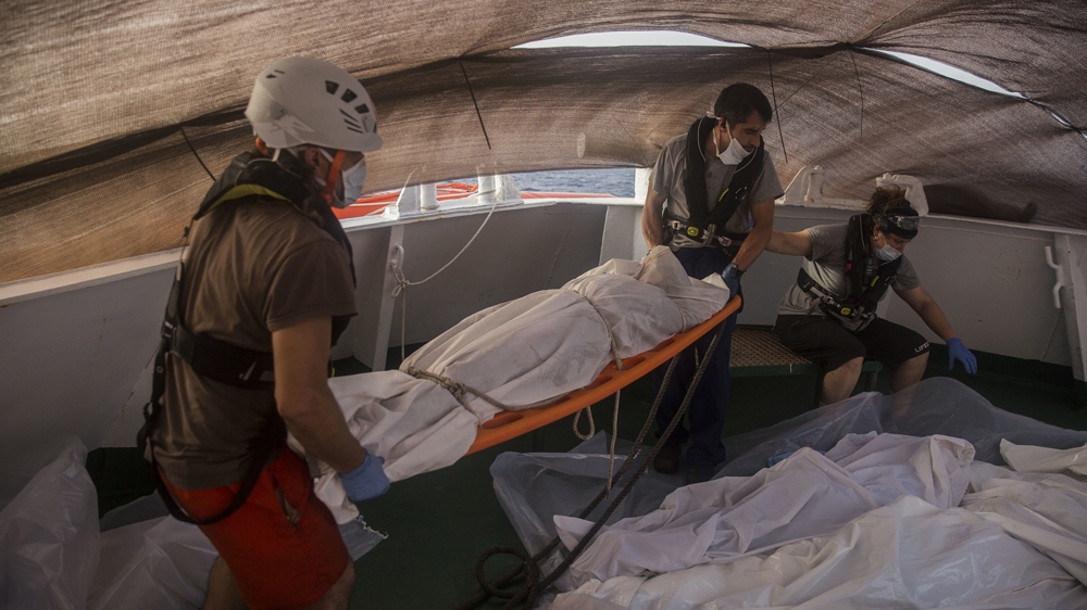 Aid workers of Proactiva Open Arms recover dead bodies of refugees and migrants in the Mediterranean [File:Santi Palacios/AP Photo]