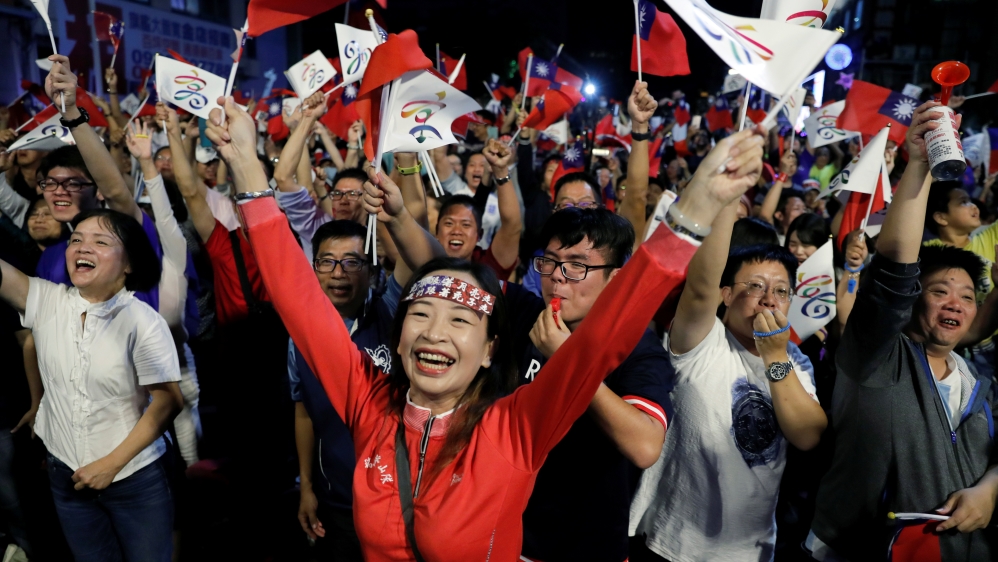 Supporters of nationalist opposition, Kuomintang (KMT), celebrate after the results [Tyrone Siu/Reuters]