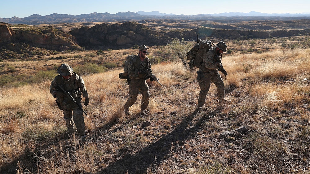 Members of the Arizona Border Recon search for immigrants at the US-Mexico border near Arivaca, Arizona in 2016 [John Moore/Getty Images] 