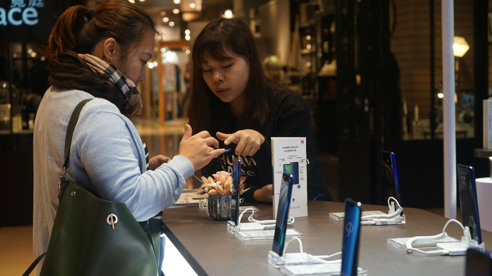 Shoppers buy mobile phones in the capital, Taipei, which has one of the world's highest rates of internet penetration [James Reinl/Al Jazeera] 