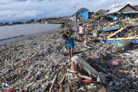 Residents walk among debris after the tsunami at Labuan in Pandeglang