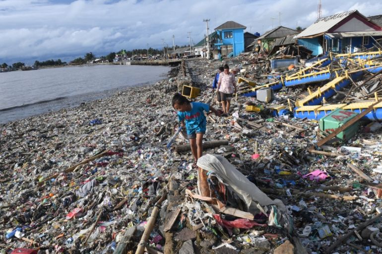 Residents walk among debris after the tsunami at Labuan in Pandeglang