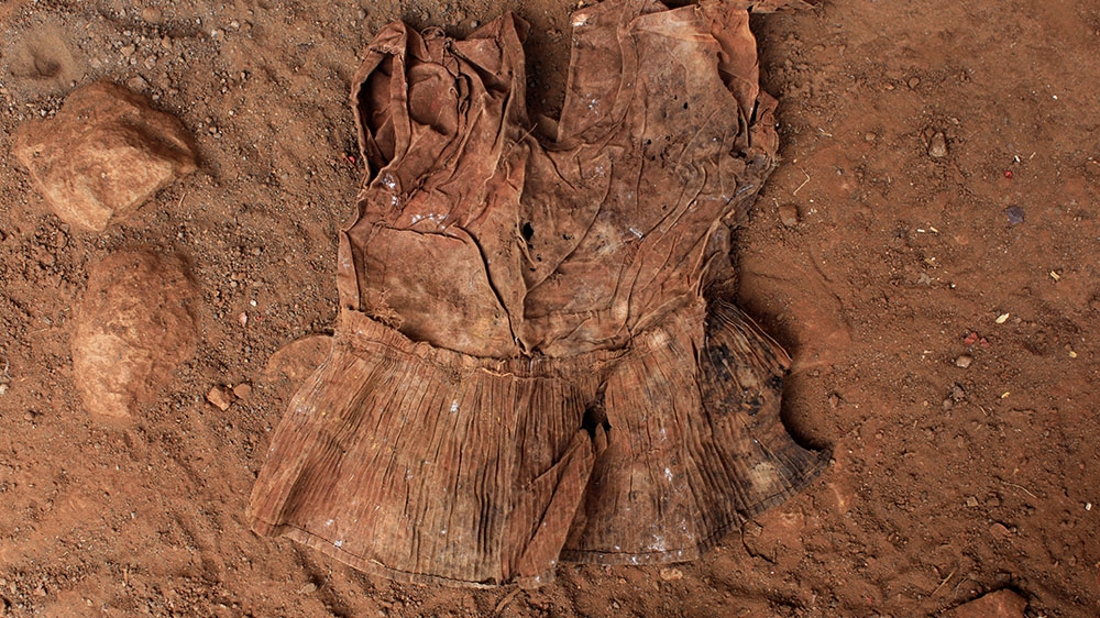 A dress found at an exhumation site is photographed in the village of El Mozote, Meanguera [File: Jose Cabezas/Reuters]