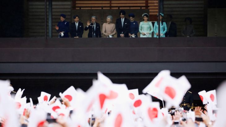 Japan's Emperor Akihito, flanked by Empress Michiko, Crown Prince Naruhito, Crown Princess Masako and other royal members wave to well-wishers who gathered to celebrate the