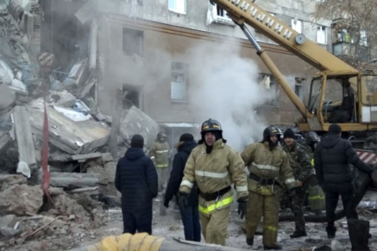 This photo provided by the Russian Emergency Situations Ministry taken from tv footage shows Emergency Situations employees working at the scene of a collapsed section of an apartment building, in Mag