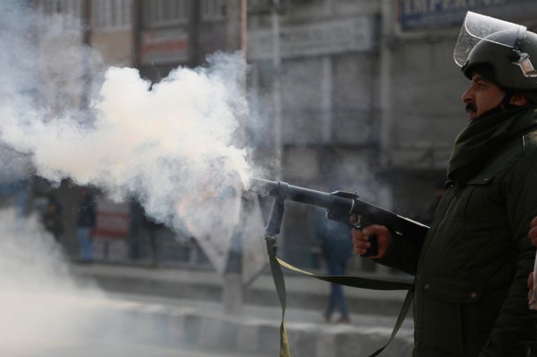 An Indian police officer fires tear smoke shell on Kashmiri protesters attempting to march to an Indian military base in Srinagar, Indian-controlled Kashmir, Monday, Dec. 17, 2018. Armed soldiers