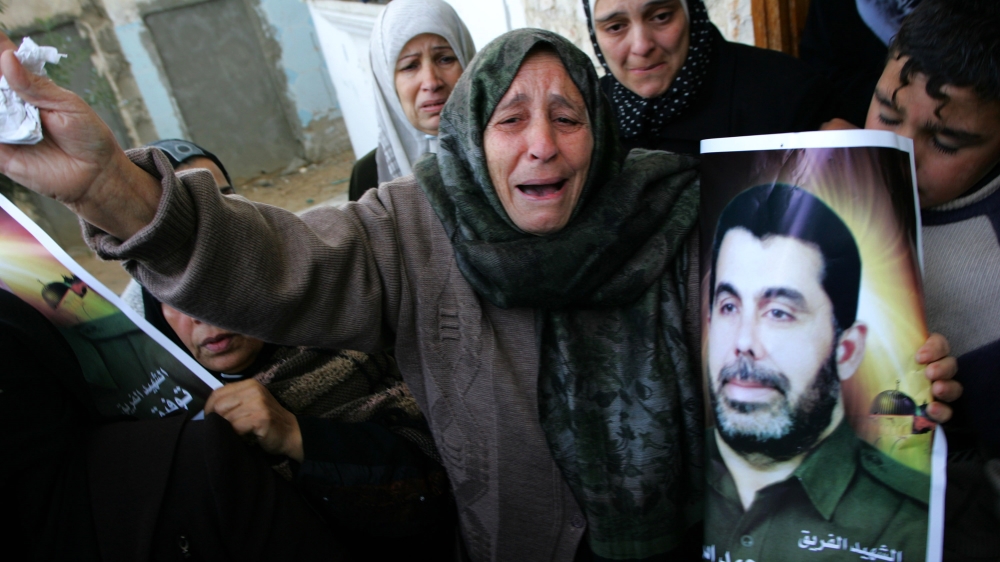 Relatives of Palestinian police chief Tawfiq Jaber, who was killed in an Israeli air raid, hold pictures of him at his funeral on December 28, 2008 [File: Getty Images]