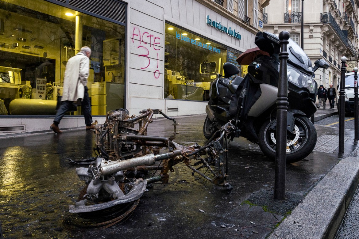 A burnt motorbike is seen left on a street where a graffiti using the name of the last Saturdayi´s protests i`Act 3i^ was written on December 03, 2018 in Paris, France. While the final cost of the des