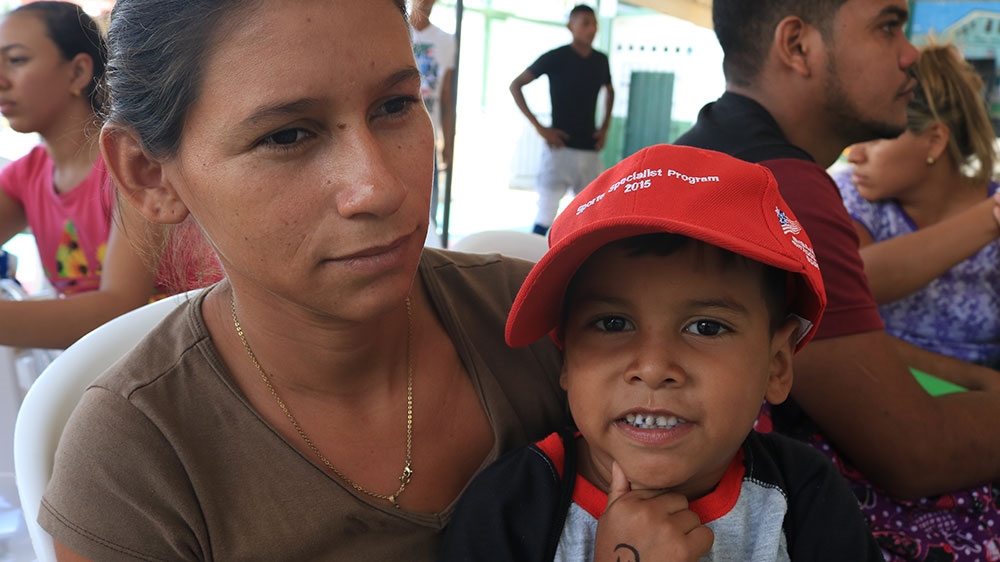 Yulibet Valero and her son Wilmer wait for case processing at a temporary American medical site in Riohacha, Colombia [Dylan Baddour/Al Jazeera] 