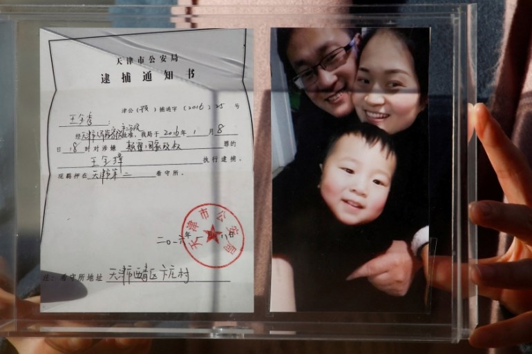 Li Wenzu holds family picture and husband''s detention notice in Beijing
