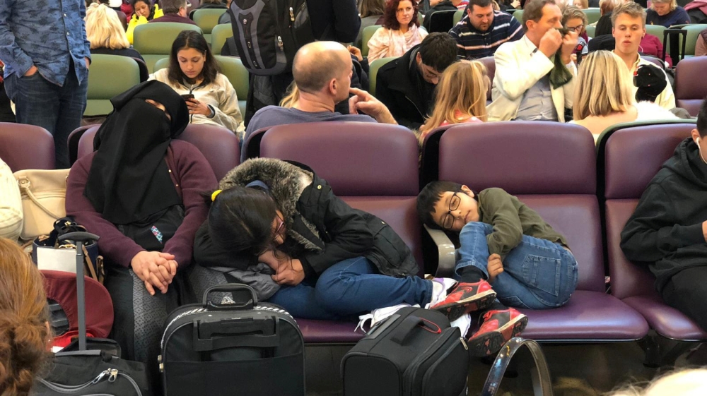 Stranded passengers are seen sleeping at Gatwick Airport [Ani Kochiashvili/Reuters]