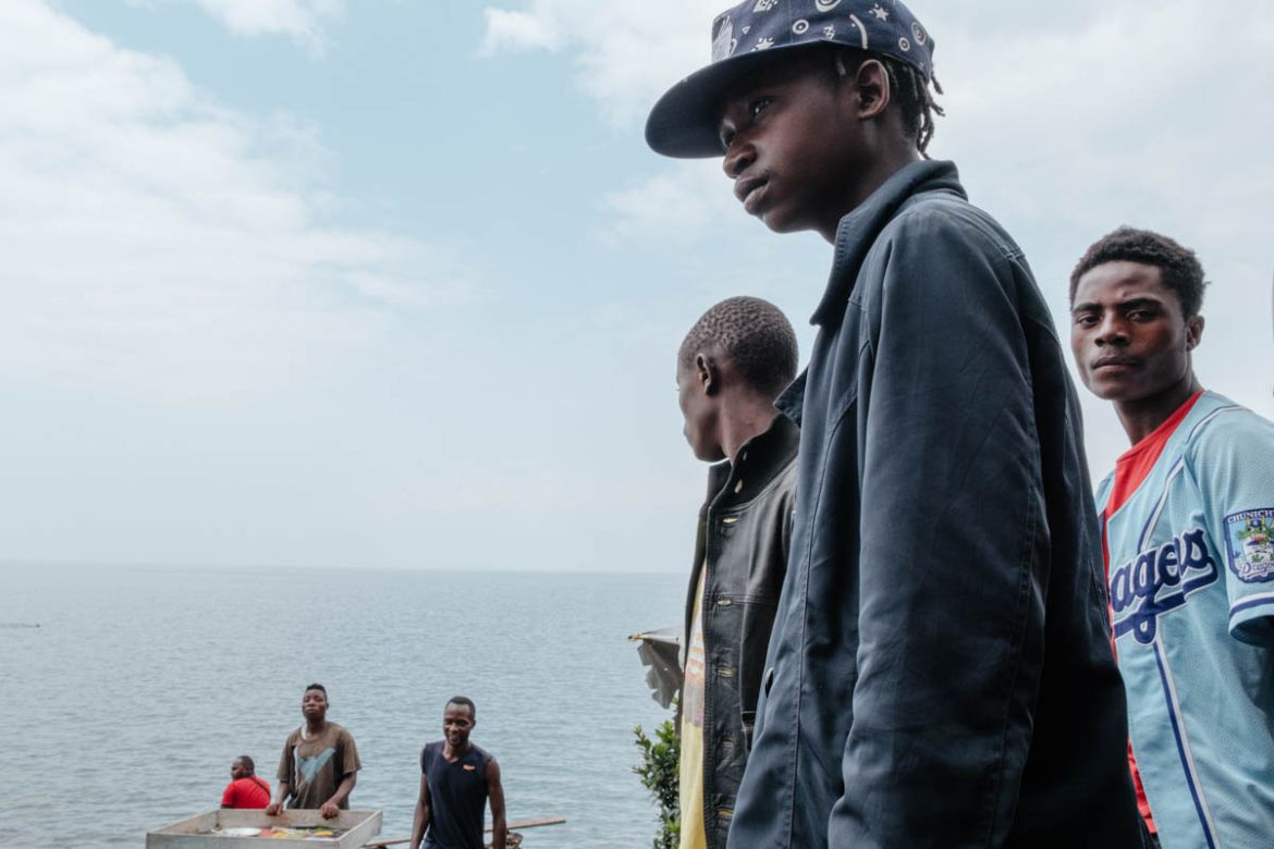 . Ivoire Papati Dance (19) stands in “Miami Beach” on the shores of Lake Kivu. “We are here because of our life condition… some of us have parents, and others don’t,” he explains his situation soberly