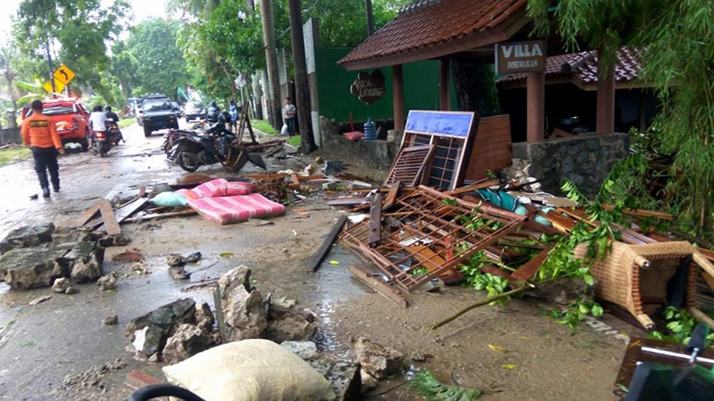 Debris from damaged buildings littered the streets on Carita beach [Ronald/AFP]