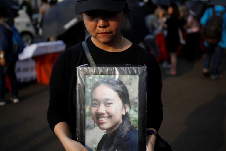 A woman holds a portrait picture of a relative, one of the 189 people killed in a Lion Air plane crash, during a rally in Jakarta