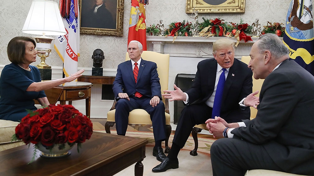 Trump (second from the right) argues about border security with Senate Minority Leader Chuck Schumer (right) and House Minority Leader Nancy Pelosi as Vice President Mike Pence sits nearby in the Oval Office [Mark Wilson/Getty Images/AFP] 