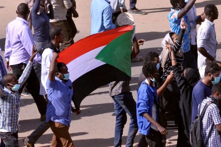 Sudanese demonstrators chant slogans as they march along the street during anti-government protests in Khartoum