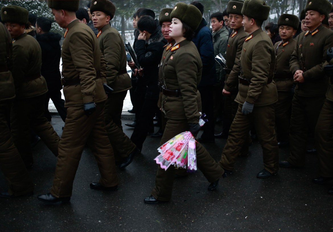 A member of North Korean military holds flowers to be laid at the bronze statues of the late leaders Kim Il Sung and Kim Jong Il at Mansu Hill Grand Monument in Pyongyang, North Korea, Monday, Dec. 17