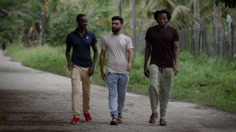 Aziz Abdul Muhamat walks with friends on Manus Island [Bill Code/Al Jazeera]