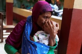 A woman holds a child at a shelter in Cigeulis, after a tsunami hit Banten province
