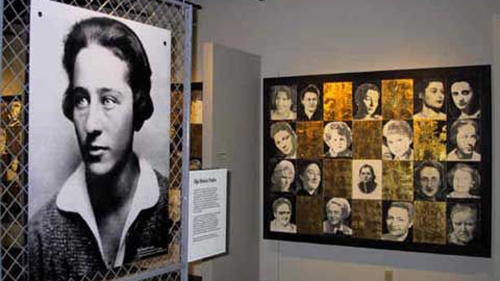 A photograph of Olga Benario Prestes in the exhibit 'Women of Ravensbruck - Portraits of Courage', curated by Rochelle Saidel for the Florida Holocaust Museum. Artwork on the right by Julia Terwilliger 