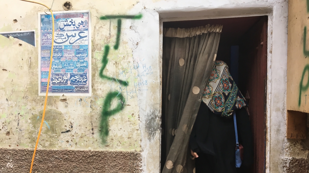 The entrance to the building where the cafe is located, with 'TLP' spray-painted [Zehra Abid/Al Jazeera]