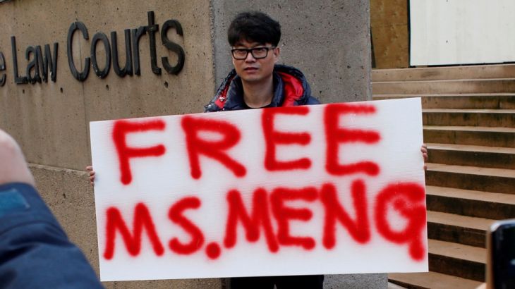 A man holds a sign outside of the B.C. Supreme Court bail hearing of Huawei CFO Meng Wanzhou, who is being held on an extradition warrant in Vancouver