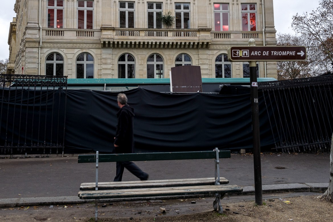 A man passes in front of a closed building vandalized by extremists groups during last Saturdayi´s i`Gilets Jaunesi^ protests on December 03, 2018 in Paris, France. The Arc du Triomphe was vandalized