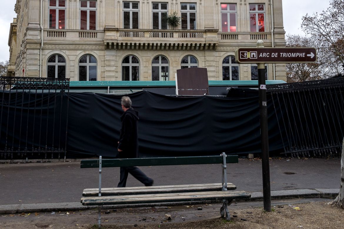 A man passes in front of a closed building vandalized by extremists groups during last Saturdayi´s i`Gilets Jaunesi^ protests on December 03, 2018 in Paris, France. The Arc du Triomphe was vandalized